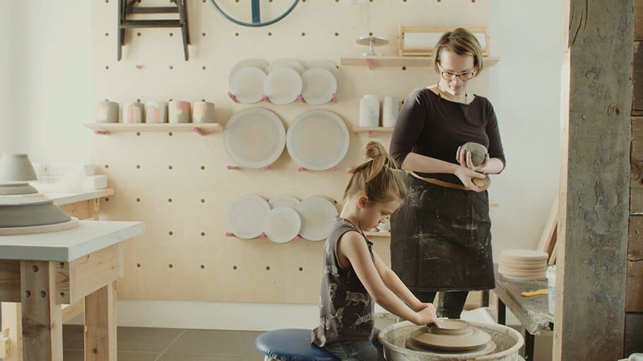 Une femme et un enfant travaillant dans un atelier de poterie.